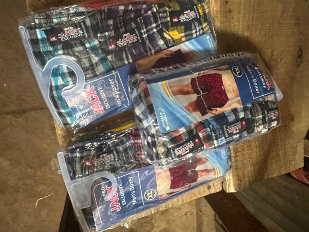 Multiple packaged Pro Jack Exclusive men's boxers in various plaid patterns and sizes.