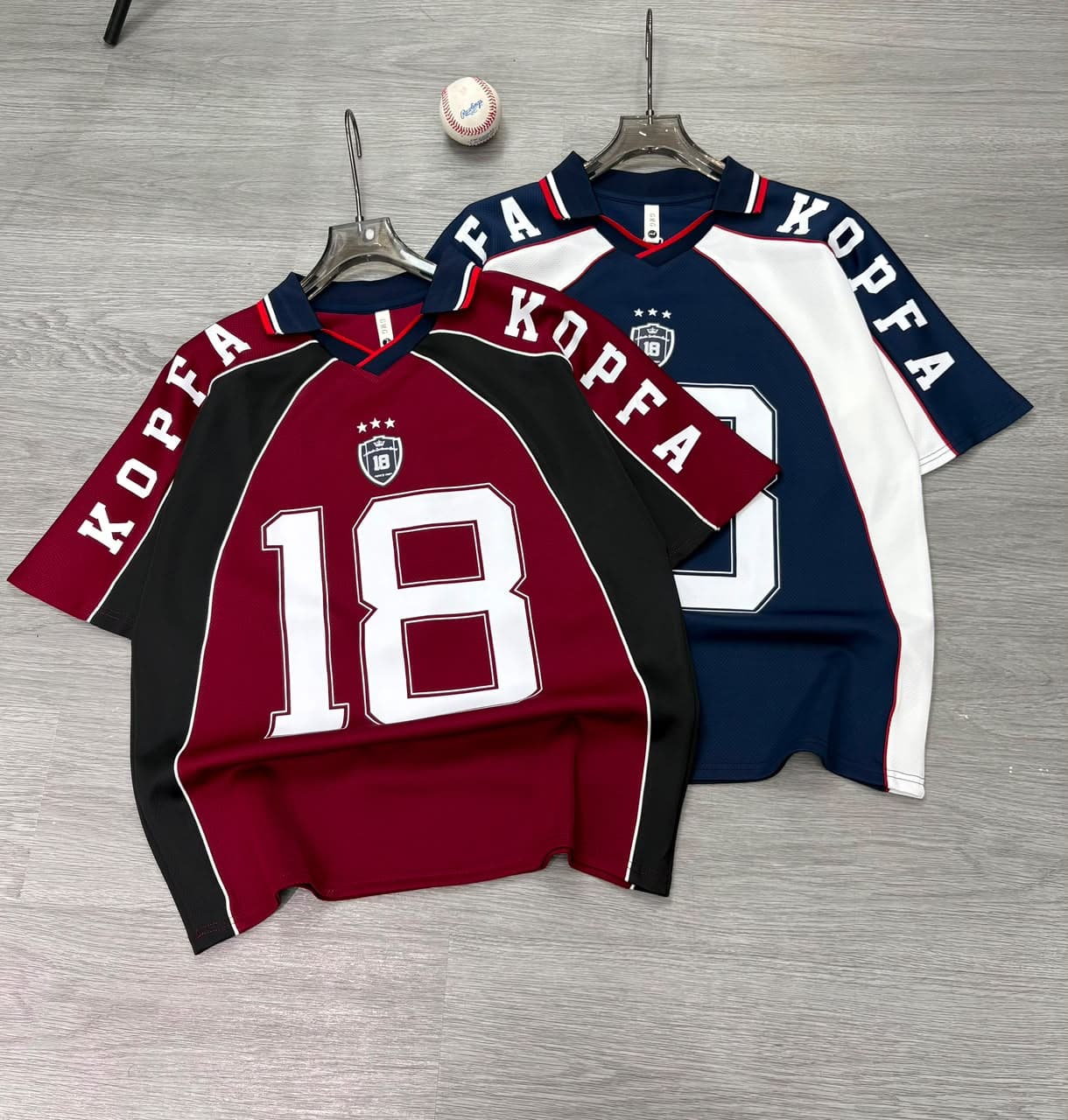 Navy Kopfa 18 jersey T-shirt on hanger, front view with sleeve and chest details.