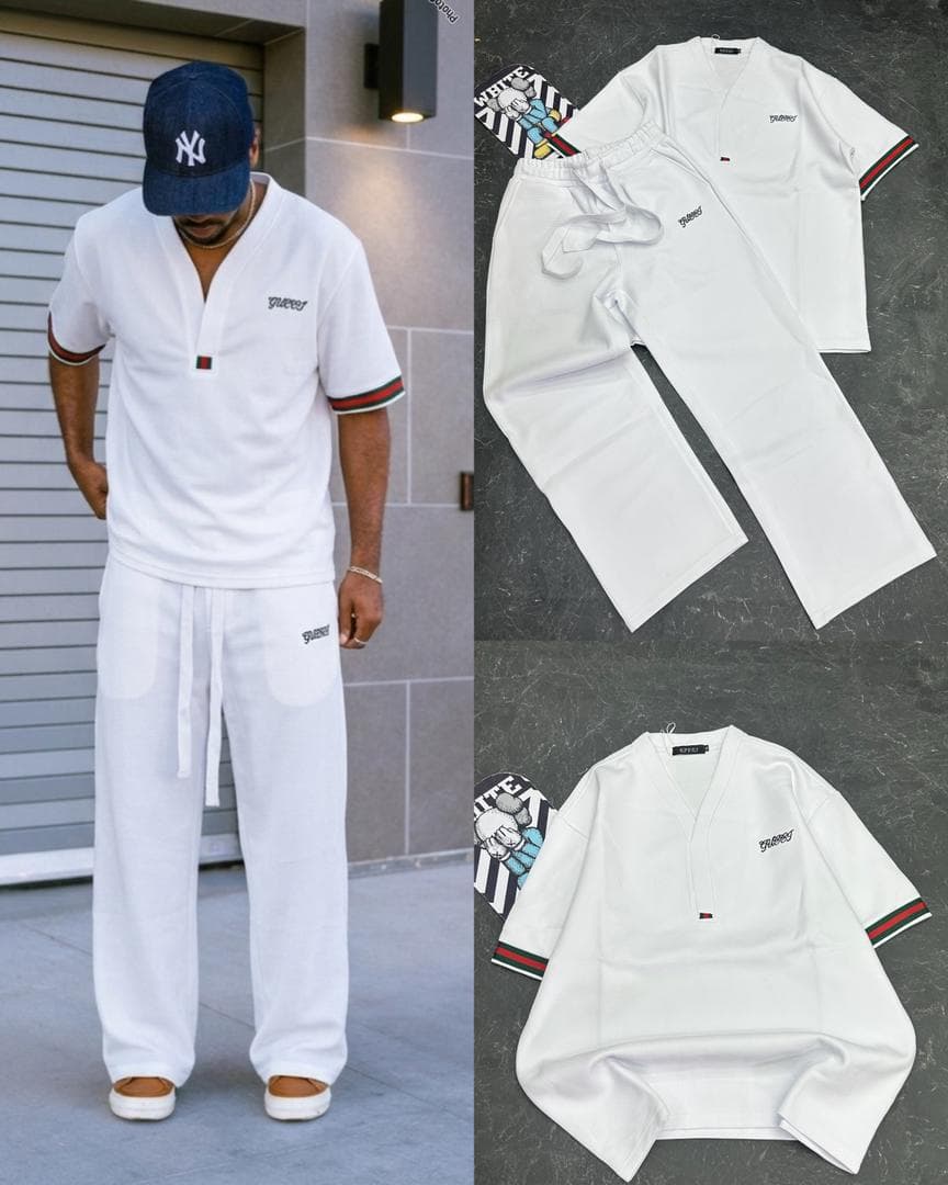 Flat lay of white Gucci two-piece set with V-neck top, drawstring trousers and white sneakers on gray background.