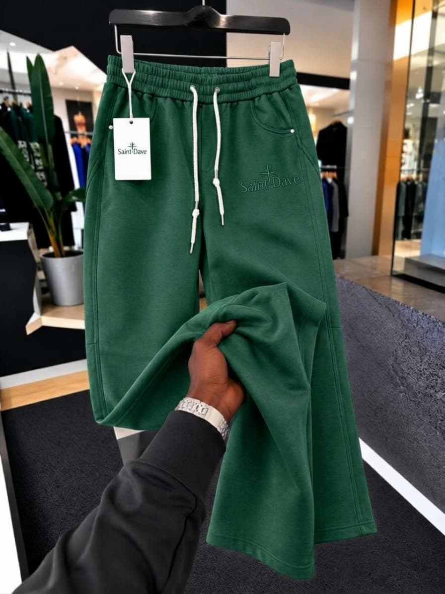 Black SEVEERS striped joggers on hanger with hand holding leg to show details and emblem.