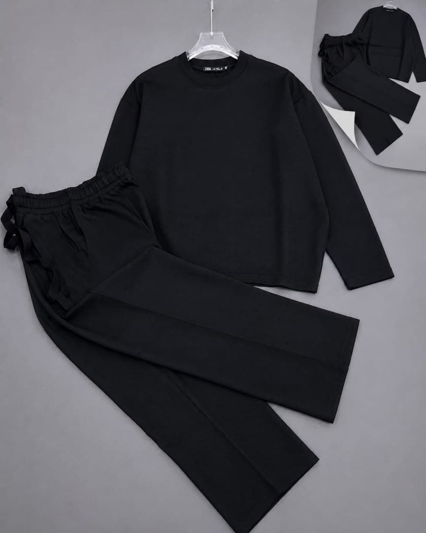 Black oversized long sleeve crewneck top and matching drawstring pants two-piece set.