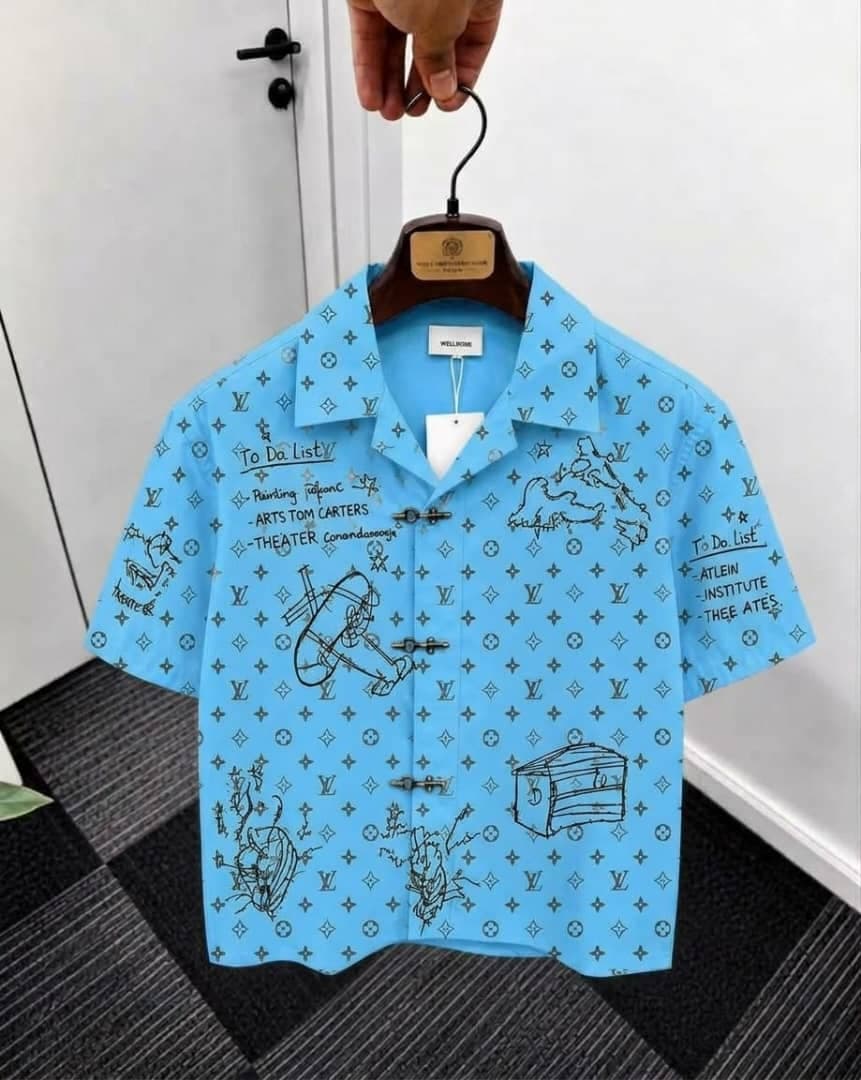 Light blue monogram sketch print short sleeve shirt on hanger.