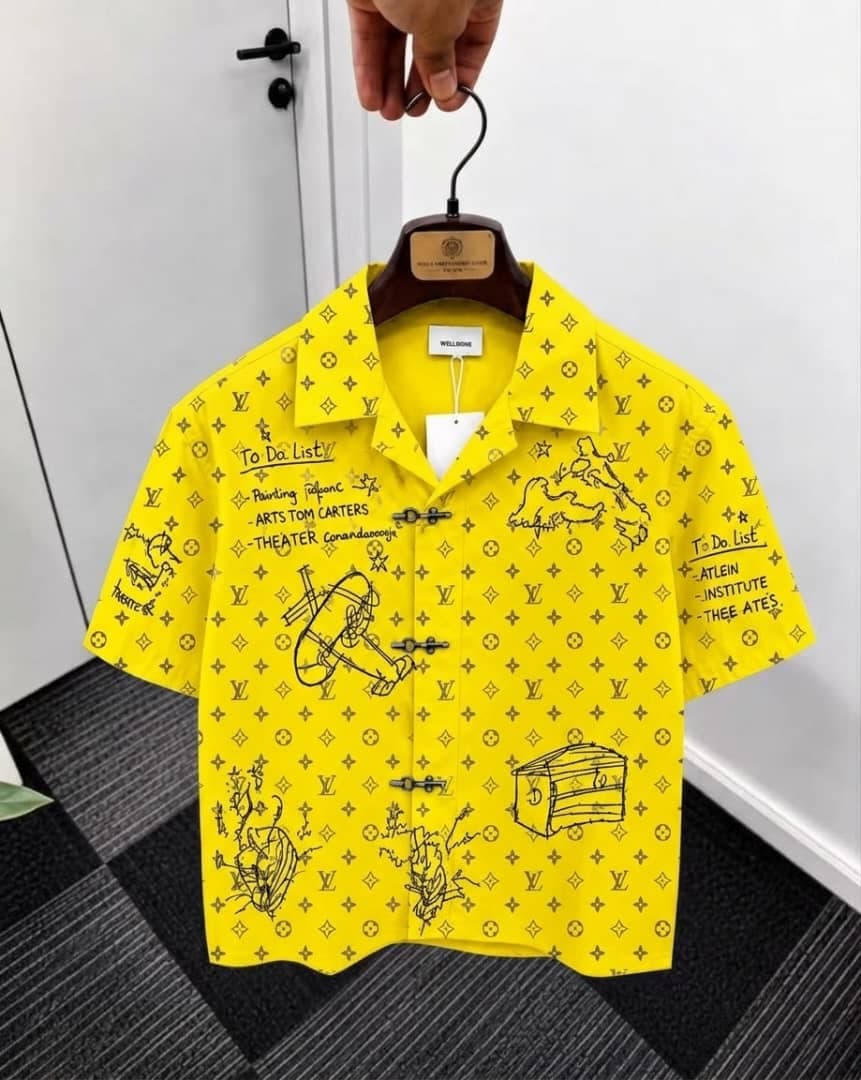 Yellow monogram sketch print short sleeve shirt on hanger.