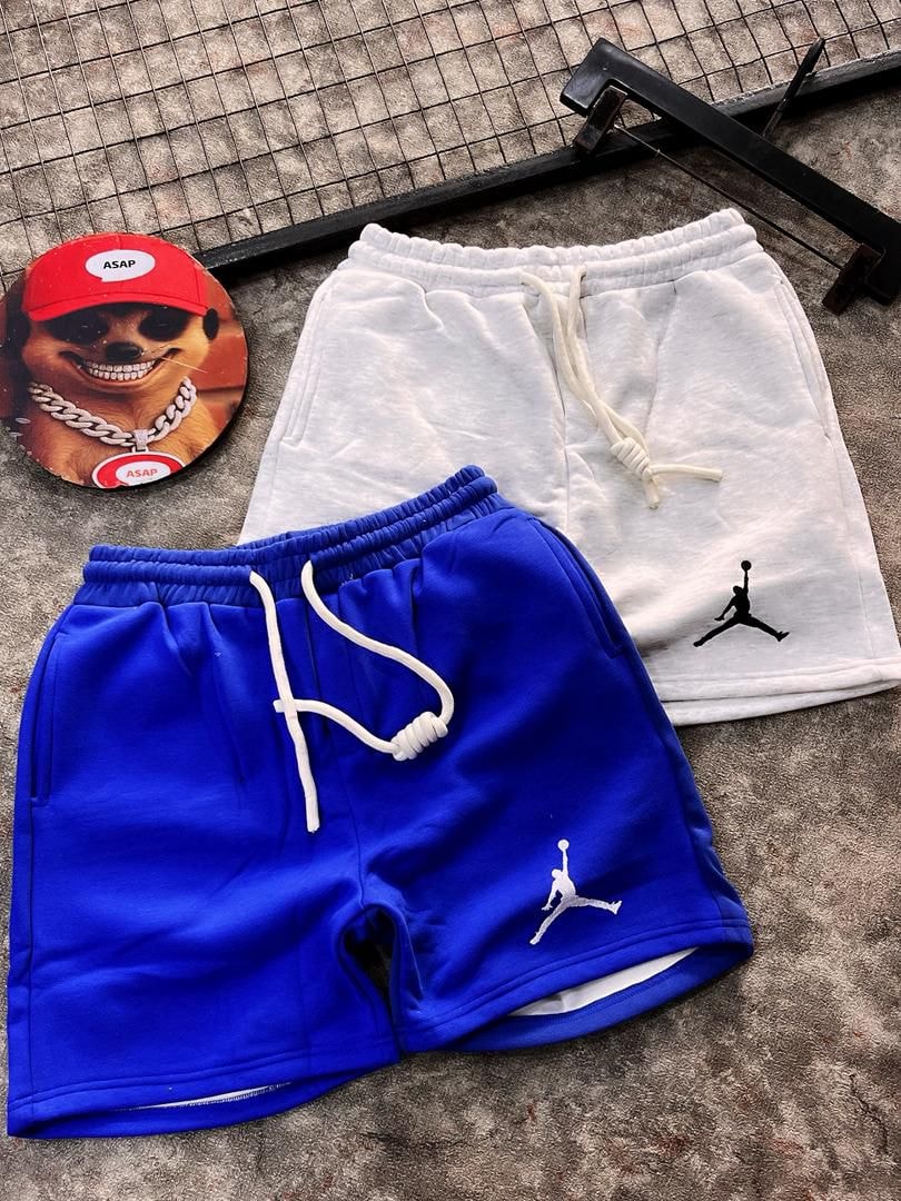 Blue and white fleece jogger shorts with Jumpman logos and drawstrings.