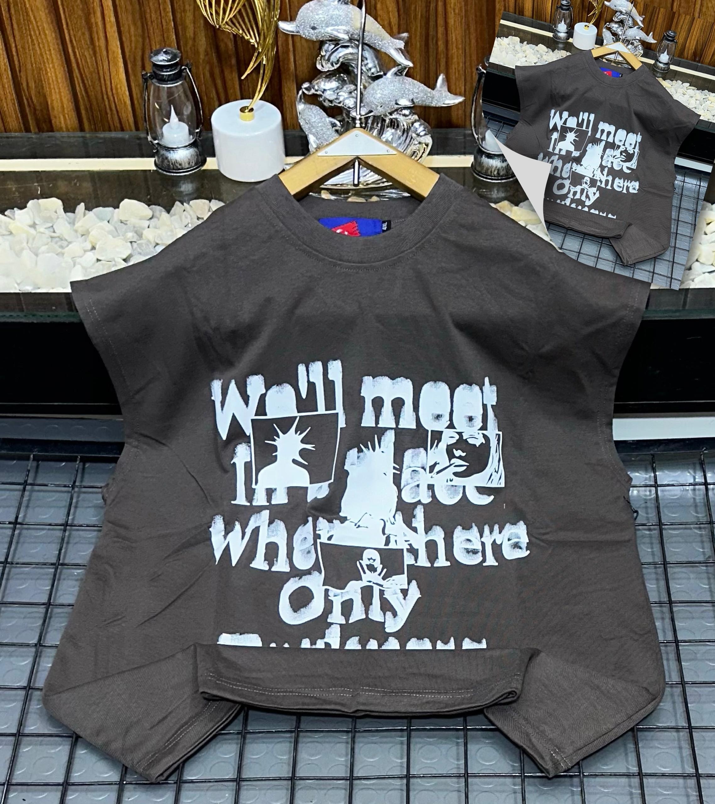 Brown armless graphic t-shirt laid flat showing front print.