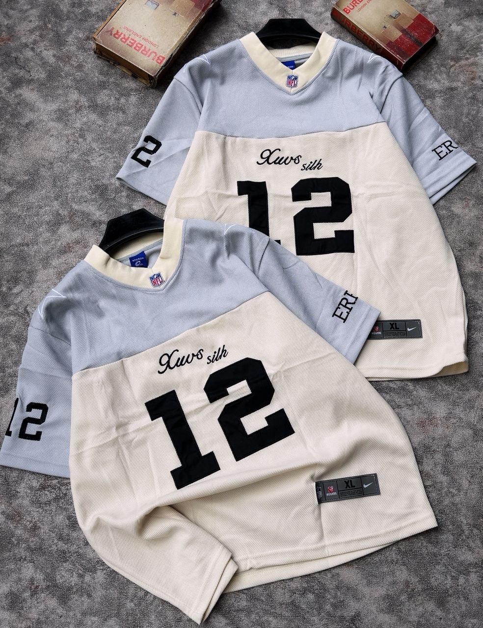Cream/gray and gray/cream Xwos silk 12 football jerseys with NFL tags and boxes.